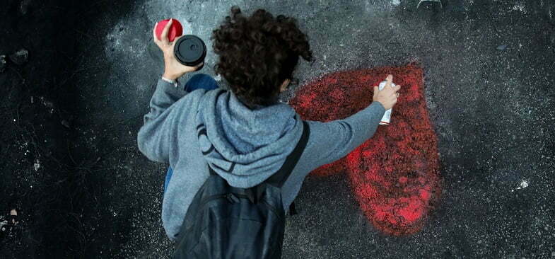 אישה מציירת לב על האספלט ביום האישה בלבנון, מארס 2021 (רויטרס)