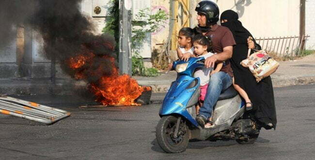 משפחה ביירותית באזור ההפגנה נגד המחדל שהוביל לפיצוץ בנמל (רויטרס)