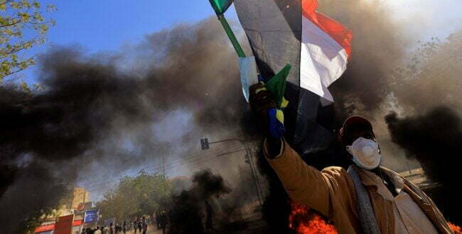 מפגין בח'רטום נגד ההפיכה, אוחז בדגל סודאן, דצמבר 2021 (צילום: רויטרס)