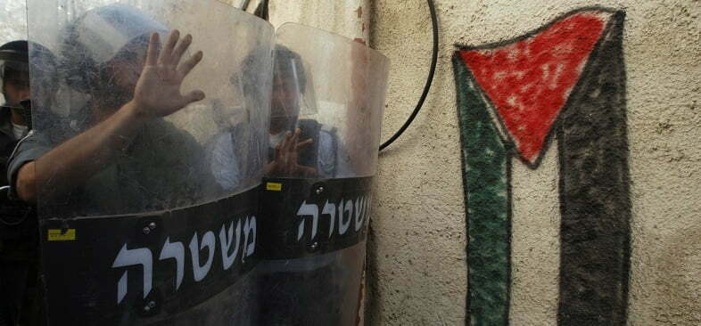 שוטרים מתגוננים מפני דגל פלסטין בשכונת ראס אל-עמוד במזרח ירושלים, מרס 2009 (צילום: רויטרס)