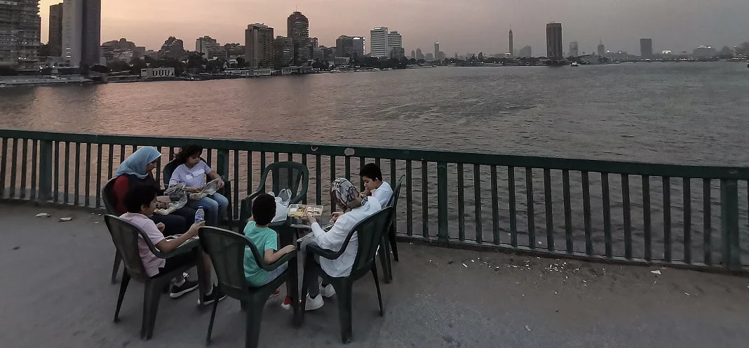 משפחה בארוחת איפטאר בגשר האוניברסיטה בגיזה, מצרים. תמונה: Omar Zoheiry/dpa