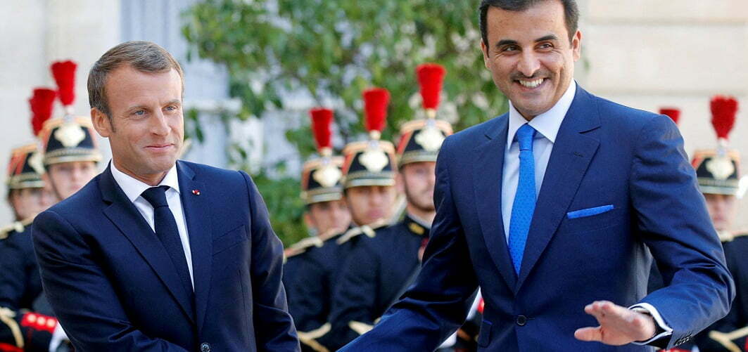 עמנואל מקרו, נשיא צרפת, לוחץ יד לאמיר קטר, שיח' תמים בן חמד אל־ת'אני. צילום: רויטרס