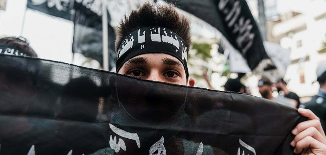 איש צעיר עם סרט לראשו עם הכיתוב: 'אנחנו חייליך, יא מוחמד'. צילום: רויטרס