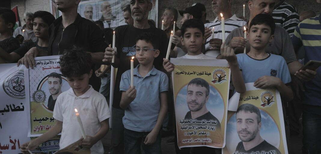 פלסטינים מחזיקים כרזות ונרות בעיר עזה בהפגנת הזדהות עם אסיר חולה סרטן, 2022. צילום: רויטרס