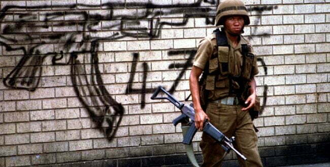 חייל על רקע גרפיטו של קלצ'ניקוב ביוהנסבורג. צילום: רויטרס