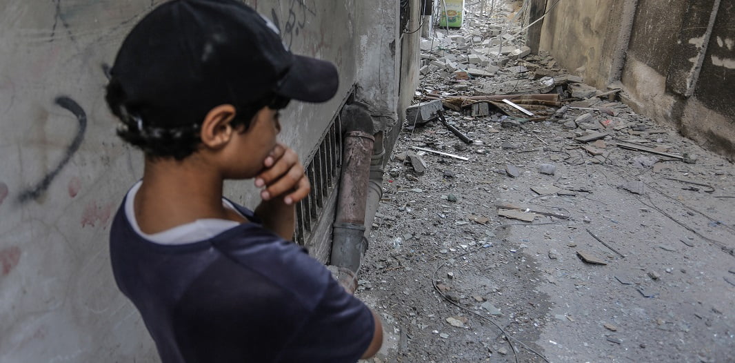 ילד פלסטיני ליד בניין שהופצץ ברצועת עזה. צילום: רויטרס