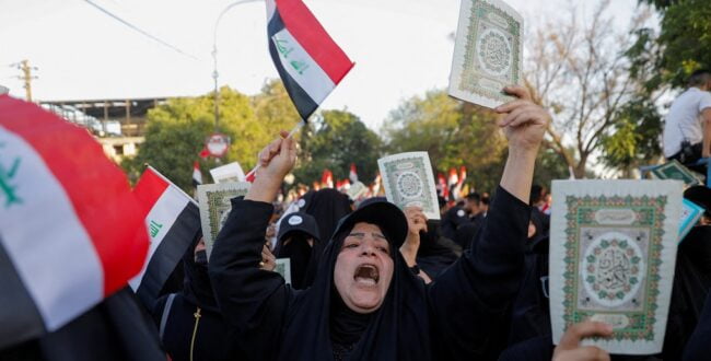 מפגינה עיראקית מחזיקה קוראן במהלך הפגנה נגד שריפת הקוראן בשבדיה. צילום: רויטרס
