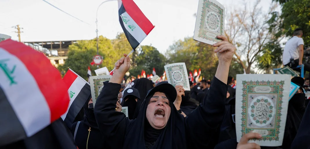 מפגינה עיראקית מחזיקה קוראן במהלך הפגנה נגד שריפת הקוראן בשבדיה. צילום: רויטרס