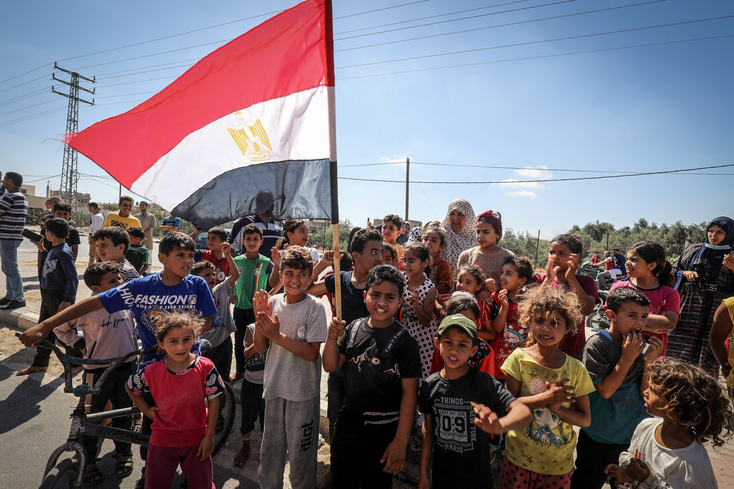 ילדים בעזה מקבלים פני משאיות ציוד שנכנסות לעזה ממצרים דרך מעבר רפיח, 4 ביוני 2021 (צילום: עבד רחים ח'טיב / פלאש90)
